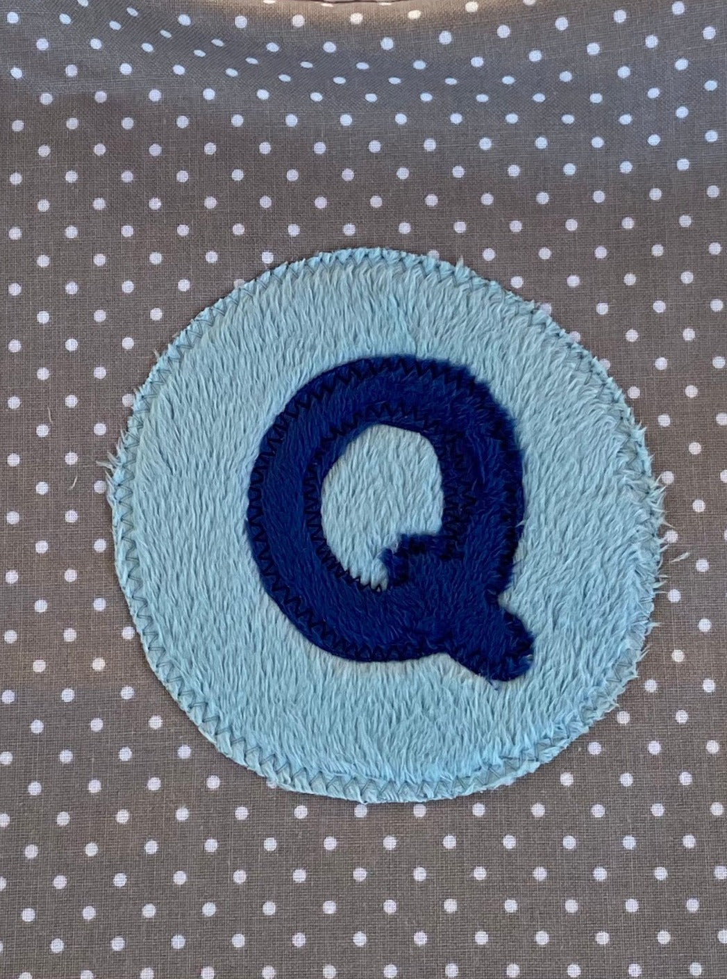 Tiny dot bib with navy blue initial and light blue circle